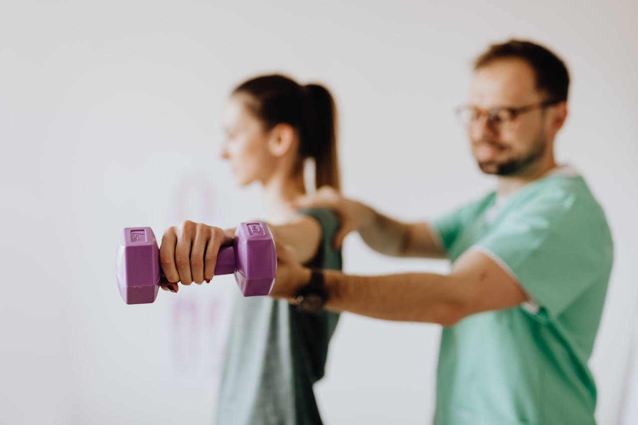 Crafting Captivating Headlines: Your awesome post title goes here Side view of professional orthopedist in uniform and eyewear helping fit woman reaching arm with dumbbell in doctor office on blurred background